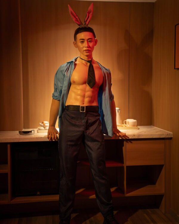 Mendolls realistic gay doll silicone, hyper-realistic and smooth, posed in a romantic Pride event setting