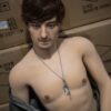 Beau gay sex doll sitting on leather sofa